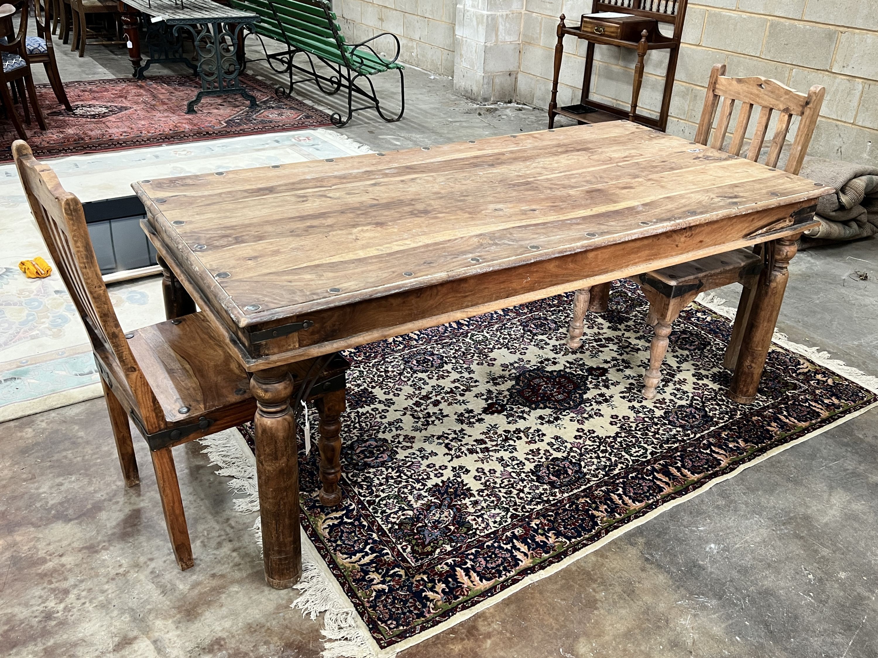 An Indonesian rectangular studded hardwood dining table, length 180cm, depth 90cm, height 76cm and two chairs